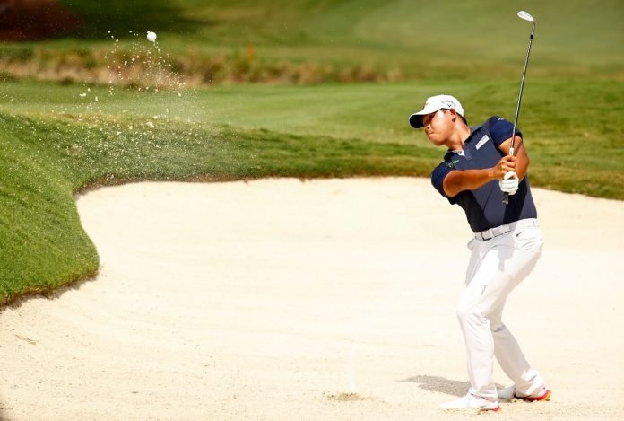 Si Woo Kim of South Korea plays a shot from a greenside bunker on the 18th hole, the second-playoff hole in a six-way sudden-death playoff, during the final round of the Wyndham Championship at Sedgefield Country Club in Greensboro, North Carolina. (Photo by Jared C. Tilton/Getty Images)