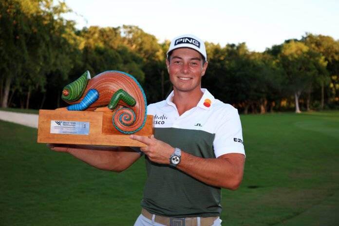 Viktor Hovland celebrates with the trophy on the 18th green after winning during the final round of the World Wide Technology Championship at Mayakoba on El Camaleon golf course earlier this month.(Photo by Mike Ehrmann/Getty Images)